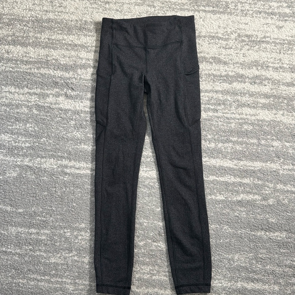 Lulu leggings with pockets on both sides and a back zip. Great for running.